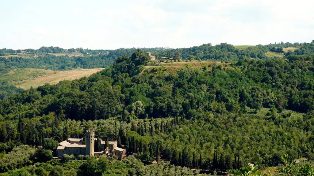 Vista della Badia immersa nel bosco dal percorso dell’Anello della Rupe.