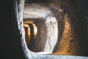 Vista leggermente scorciata di un cunicolo della Orvieto Sotterranea. Questo ha una forma pressoché circolare e lungo i lati si trovano le aperture di altri cunicoli che lo intercettano.