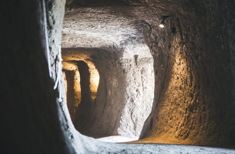 Vista leggermente scorciata di un cunicolo della Orvieto Sotterranea. Questo ha una forma pressoché circolare e lungo i lati si trovano le aperture di altri cunicoli che lo intercettano.