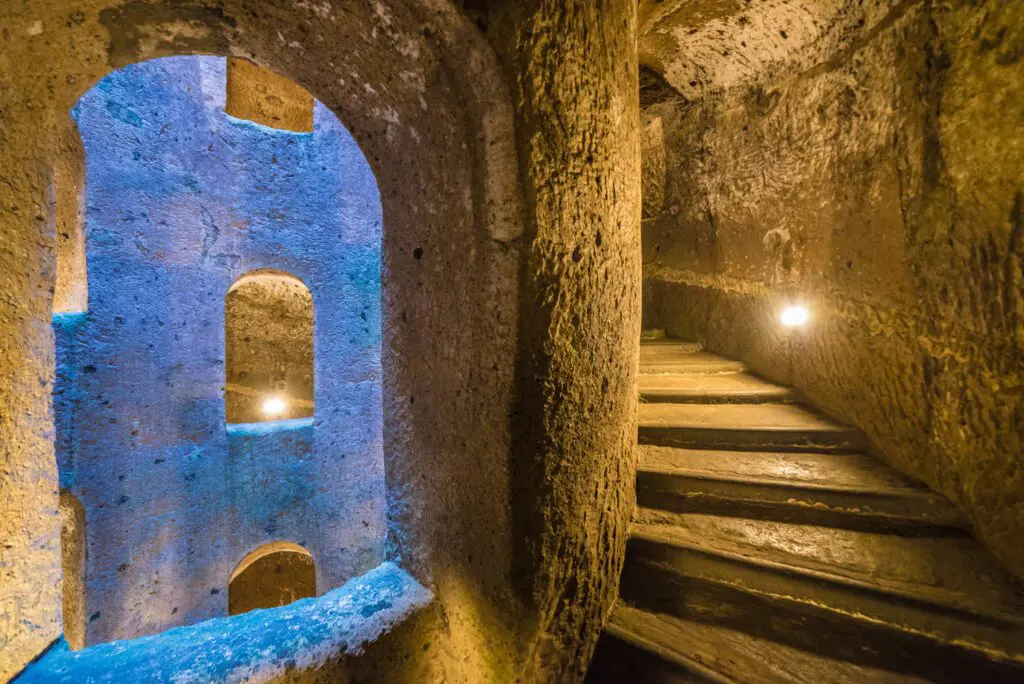 Vista del pozzo dalle scale interne, con sguardo su una delle finestre che permettono di guardare la struttura interna. Si intuisce l’andamento elicoidale della scala.