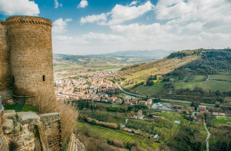 A sinistra è visibile il torrione della Fortezza Albornoz mentre il resto dell’immagine è occupato dalla vista dall’alto della città sottostante e delle campagne umbre.