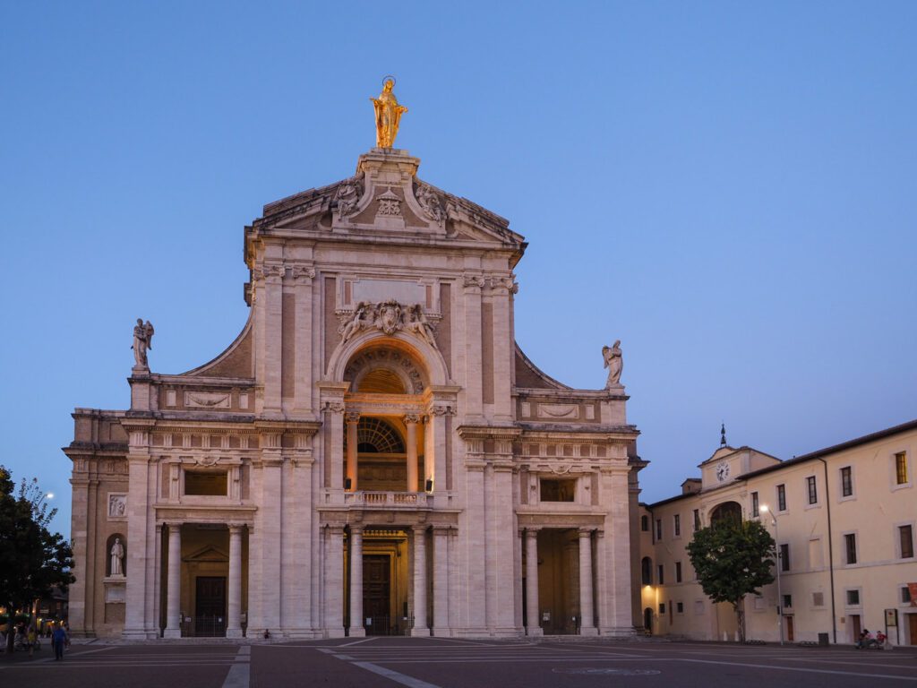 Vista della facciata di Santa Maria degli Angeli sulla cui cima campeggia l'imponente statua dorata della madonna.