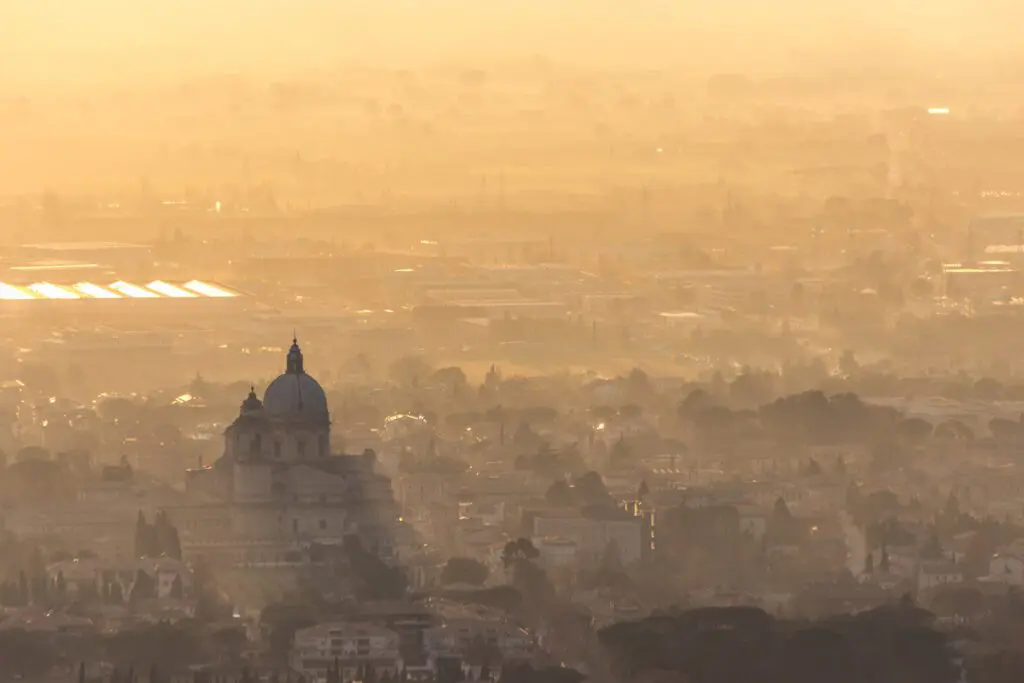 Vista aerea della Basilica di Santa Maria degli Angeli. Nella calda luce del tramonto si vede la struttura spiccare nella piana sottostante Assisi.
