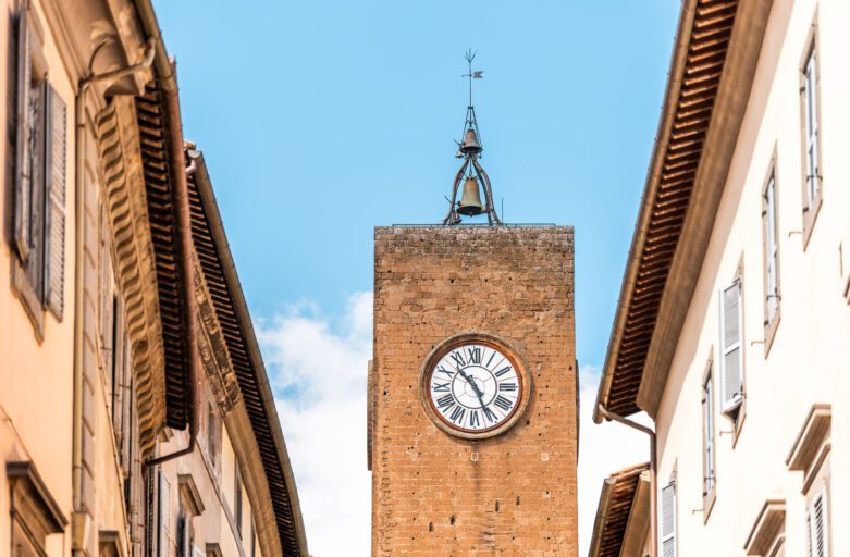 Vista dal basso della cima di Torre del Moro al centro, ai lati i tetti dei palazzi di Orvieto.