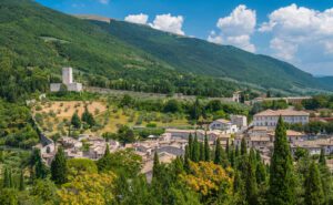 Vista panoramica della Rocca Minore. Sulla sinistra, sulle pendici boscose del monte, si trova la rocca minore. Da essa la mura si protraggono verso destra andando ad abbracciare una parte di abitato visibile.
