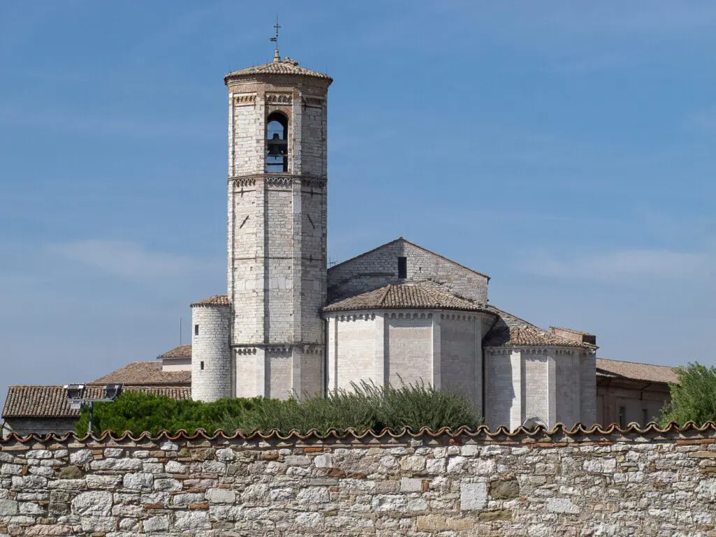 Vista dall’ esterno dell’abside della chiesa di San Francesco a Gubbio. Sulla sinistra si alza la torre del campanile, immediatamente a destra l’abside alto quasi la metà e ancora a destra un absidiolo di dimensioni inferiori al precedente.
