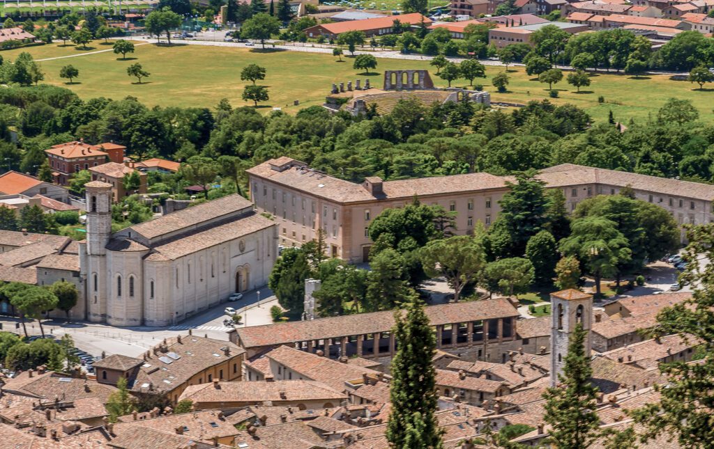Vista aerea di una porzione di Gubbio, con San Francesco ben visibile sulla sinistra. Sullo sfondo le campagne umbre e il Teatro Romano.
