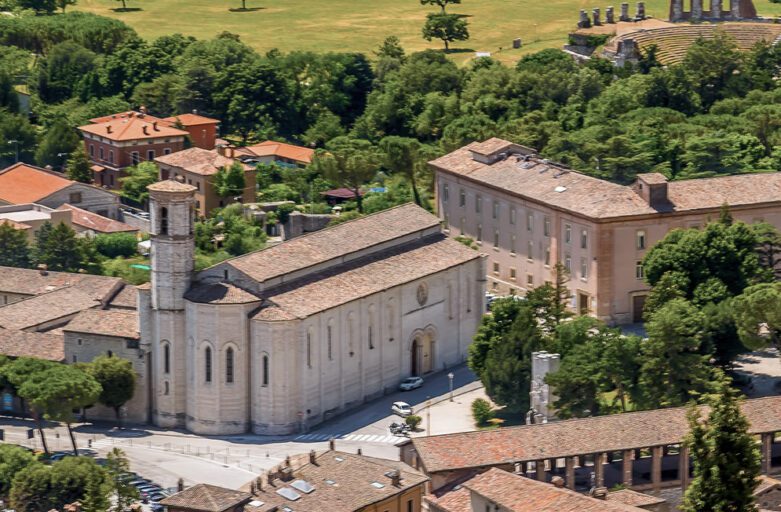 Vista aerea di una porzione di Gubbio, con San Francesco ben visibile sulla sinistra. Sullo sfondo le campagne umbre e il Teatro Romano.