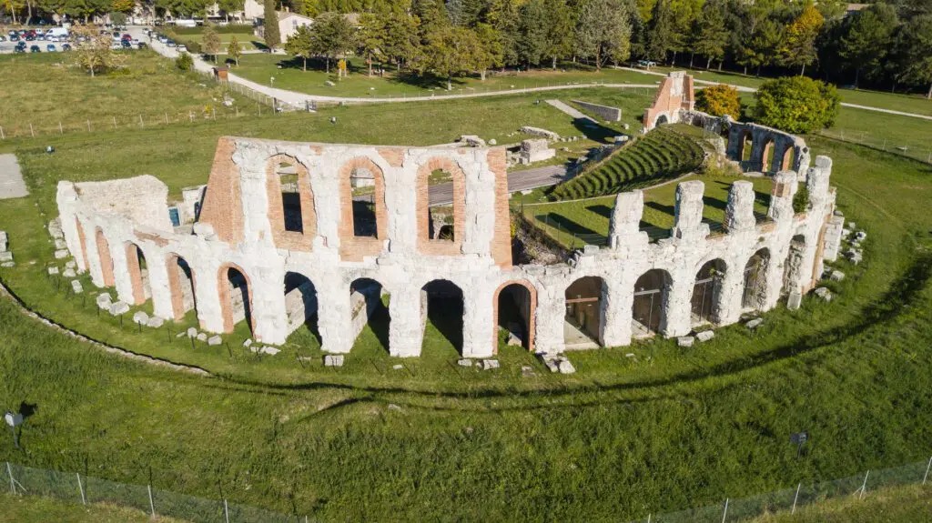Vista del Teatro romano dall’esterno, dietro alla cavea. Dei due ordini di archi che abbracciano la cavea, quello inferiore è meglio conservato mentre quello superiore è quasi totalmente perso.