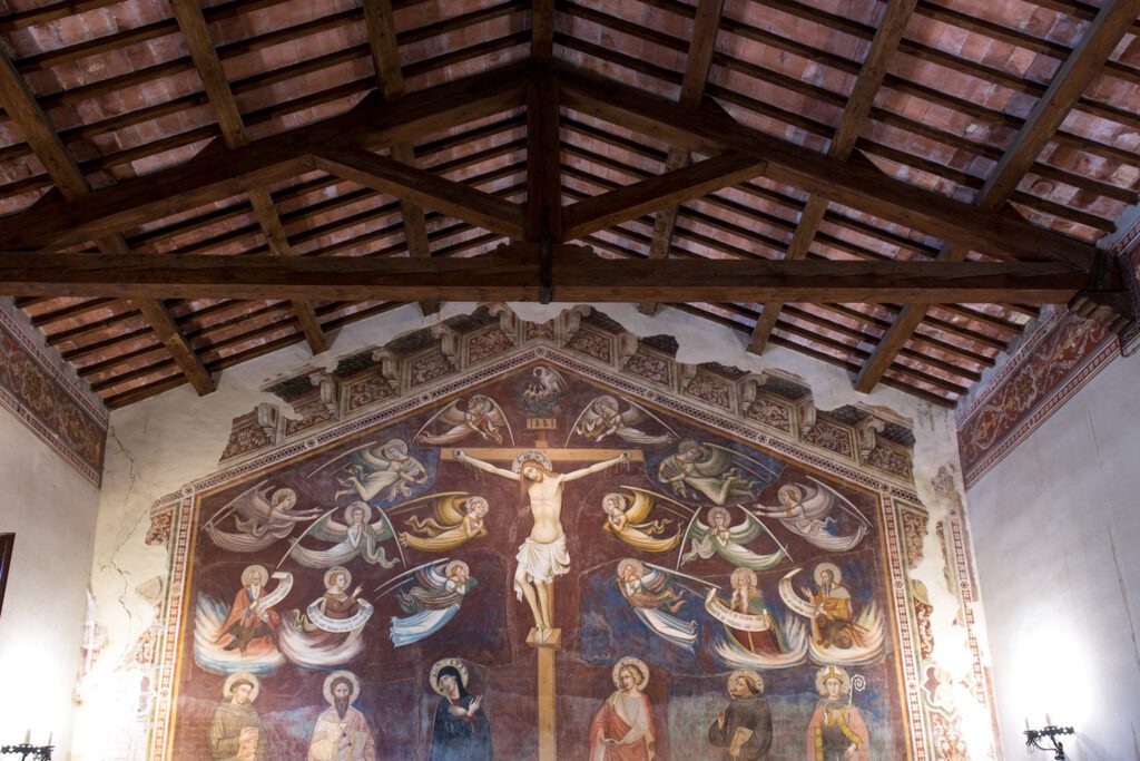Oratorio di San Bartolomeo. Vista dell'affresco di Jacopo di Mino del Pellicciaio. Sopra all'affresco, che rappresenta la Crocifissione, è visibile il soffitto a capriate lignee.