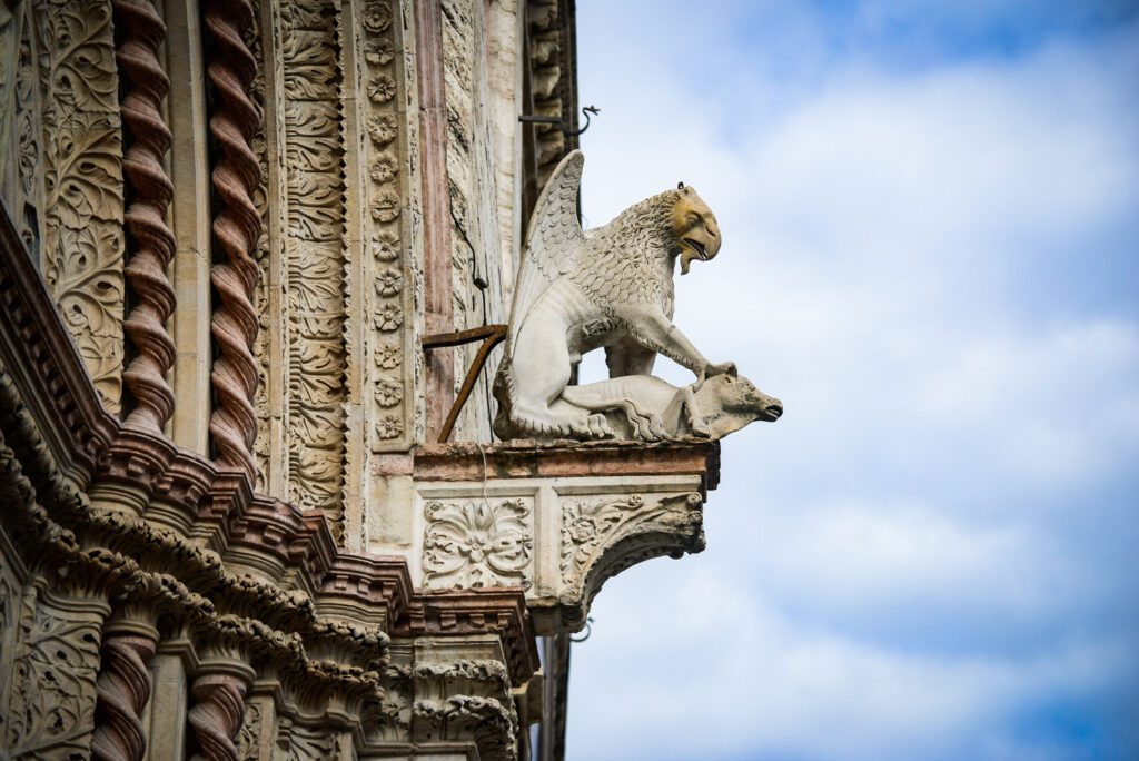 Dettaglio della statua in pietra del grifo sul portale di ingresso che affaccia su Corso Vannucci.