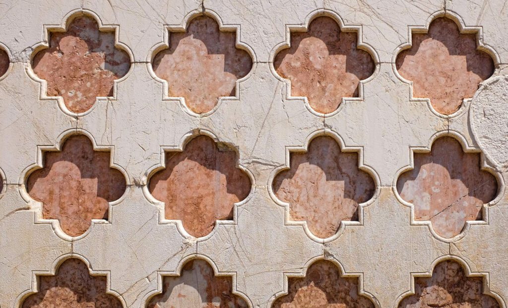 Dettaglio della facciata della Cattedrale di San Lorenzo che da su Piazza 4 Novembre. Marmo bianco con serie di rombi lobati di colore rosa.