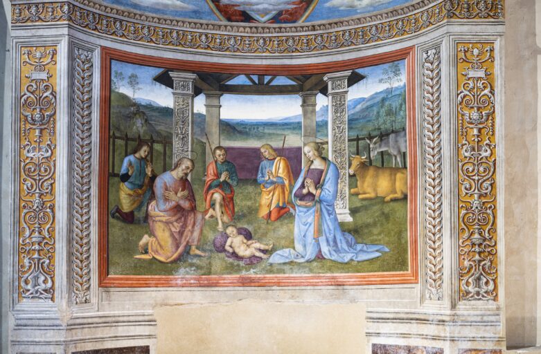 Affresco raffigurante Giuseppe e Maria che ammirano il Bambino appoggiato su un sacco a terra. Alle loro spalle tre pastori inginocchiati in adorazione e il bue e l’asino sulla destra. Dietro i pastori una capanna dallo stile architettonico rinascimentale, con un paesaggio ameno sulllo sfondo.