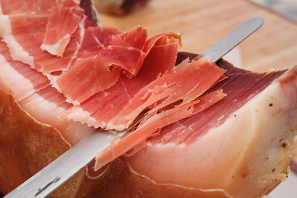 close-up image of a Norcia ham slices cut by hand with a knife