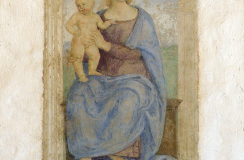 Detail of the fresco depicting the Virgin Mary seated on a wooden bench, which seems to protrude from the wall. She is portrayed in the act of supporting the Child standing on her right knee. The Child is clinging with his left hand to his mother's tunic, as if to better hold himself up. In the lower part of the fresco is the inscription 'Agniolus Toni Angeli fecit fieri MDXXII'.