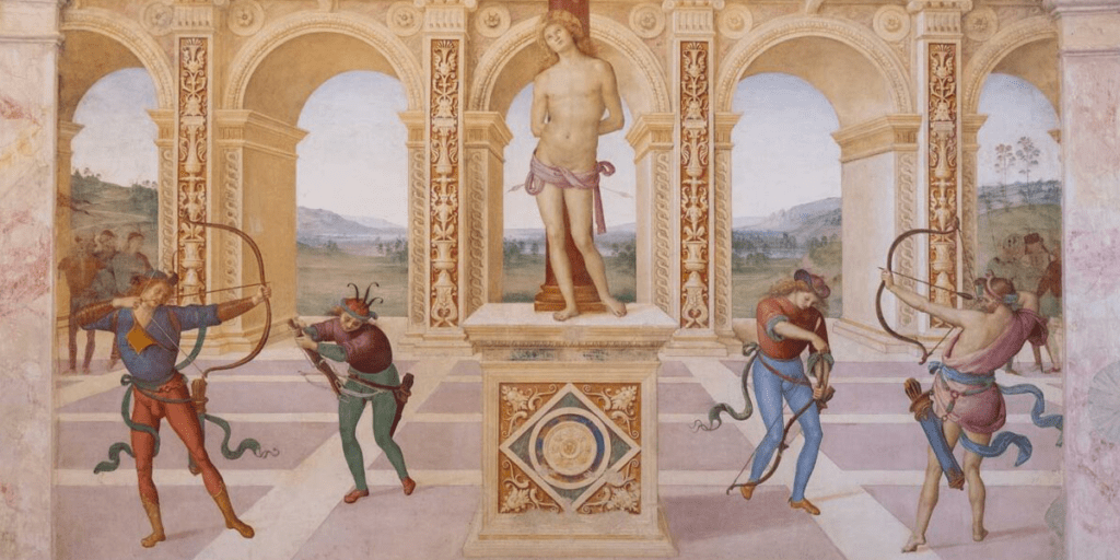 visione d’insieme dell’affresco del Martirio di San Sebastiano realizzato dal Perugino nella chiesa dell’omonimo Santo che si trova a Panicale. Al centro della scena, su una piazza pavimentata, si trova un piedistallo sopra il quale San Sebastiano è legato a una colonna, nudo e trafitto da due frecce. Il suo corpo ricorda le statue dell’epoca classica, mentre l’espressione del viso lascia trasparire un atteggiamento arrendevole, tipico della figura del martire cristiano che sacrifica la propria vita per la fede di Dio. Tre arcieri e un balestriere, divisi in due coppie, sono collocati alla destra e alla sinistra del piedistallo su cui poggia i piedi il Santo. Sullo sfondo si trova un’architettura composta da cinque arcate e un ampio paesaggio in secondo piano si intravede dietro gli archi. Nella parte superiore dell’affresco, Perugino dipinge Dio Padre all’interno di un globo di luce mentre sta compiendo il rito della benedizione, circondato ai lati da angeli.