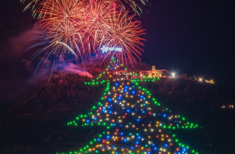 vista frontale dell’albero di Natale di Gubbio si trova sulle pendici del Monte Ingino, sopra la città di Gubbio. L’albero di Natale è fatto di luci a led che vengono accese ogni anno il 7 dicembre; questa foto è stata scattata durante il momento dell’accensione, segnato dai fuochi d’artificio. Sopra la punta dell’Albero è ben illuminata la Stella Cometa; accanto alla punta, sulla destra, è illuminata la Basilica di Sant’Ubaldo (il Santo patrono della città). Alla base dell’albero, invece, si trova la città di Gubbio.